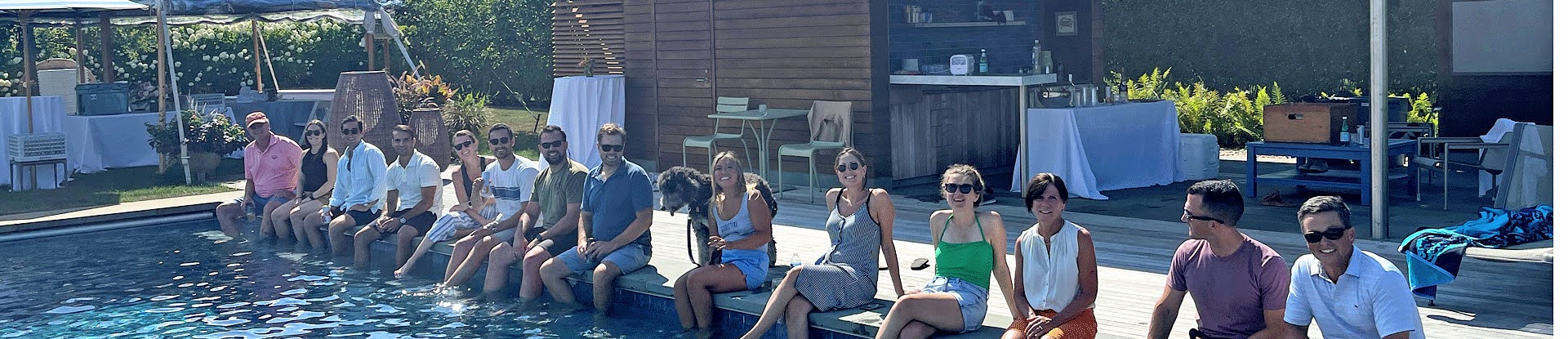 Boylston team sitting on the edge of a pool in summer