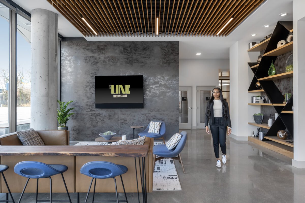 Woman walking through a common area lounge of 525 LINC coliving apartment