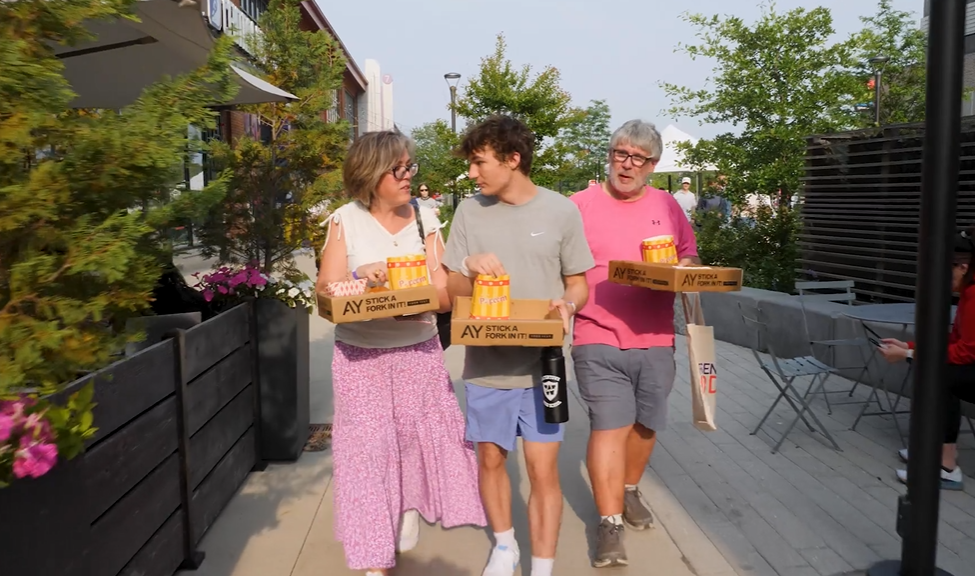 image of a family walking through Arsenal yards for the food fest, holding their trays of food