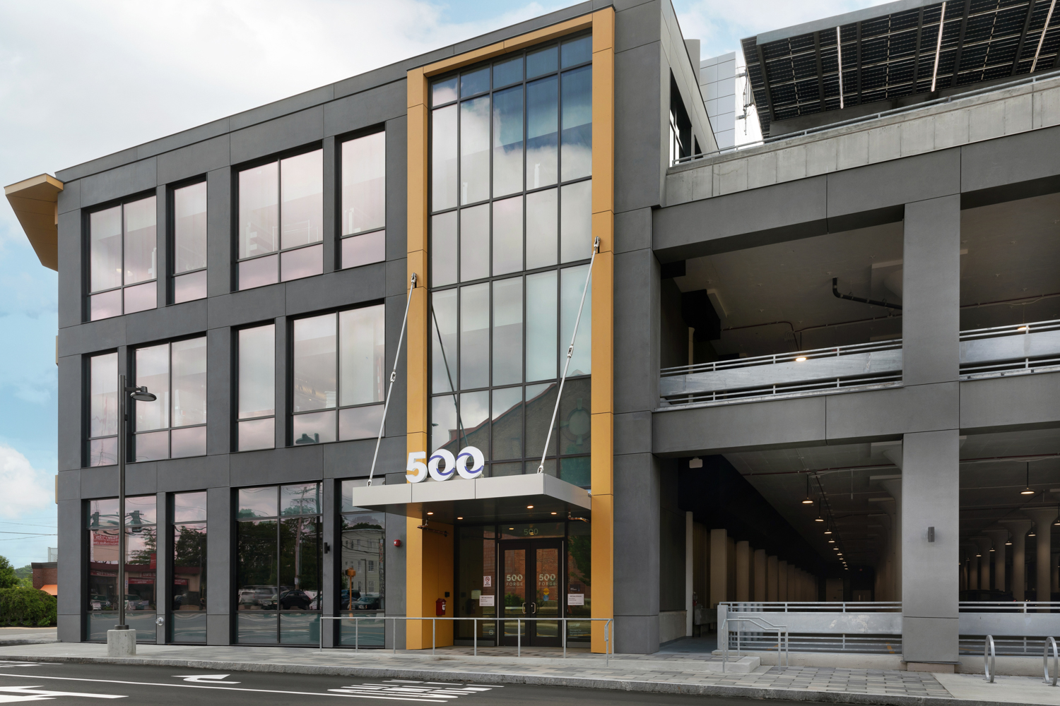 an image of the west entrance of 500 Forge, zoomed out and including part of the parking garage to the right
